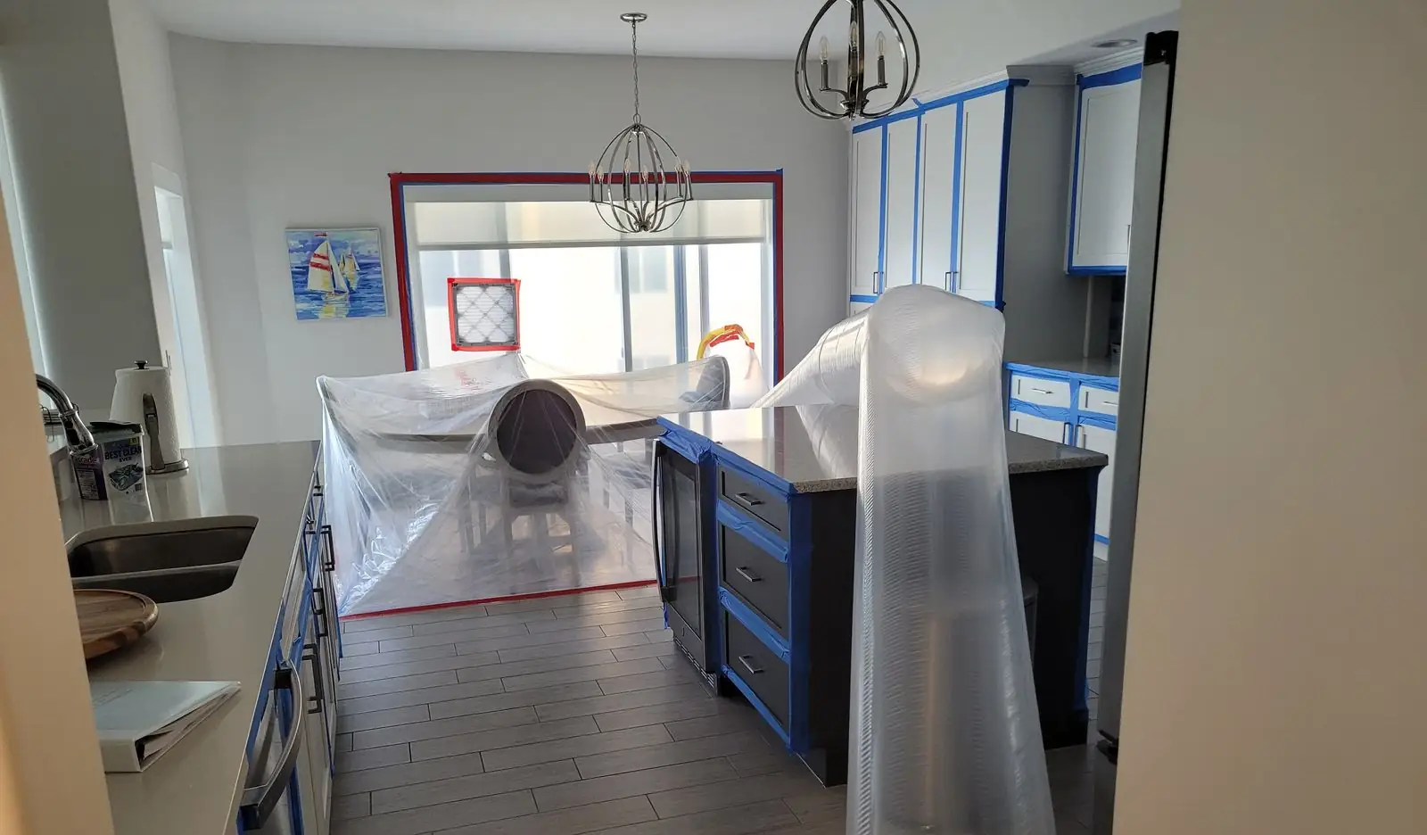 Kitchen with cabinet protection and air ducting during restoration.